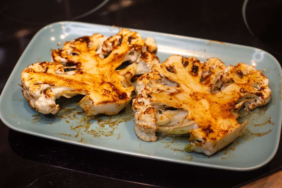 Marinated cauliflower steaks on a plate.