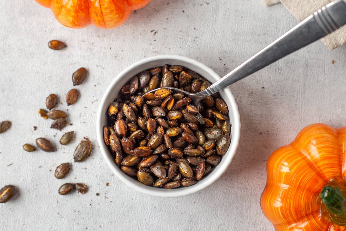 Shop-bought pumpkin seeds cooked in an air fryer and served in a bowl.