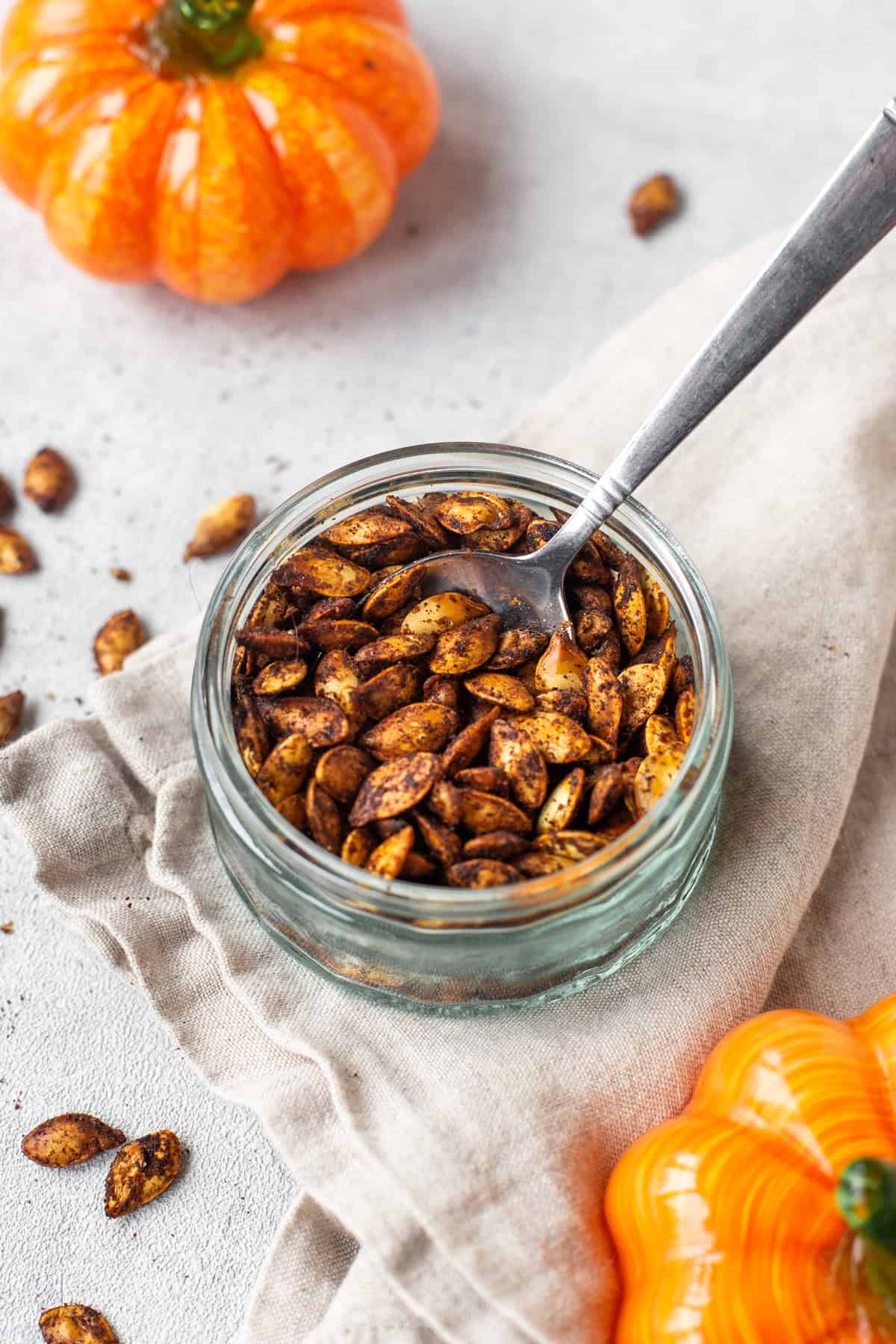 A spoon scooping up toasted air fryer pumpkin seeds.