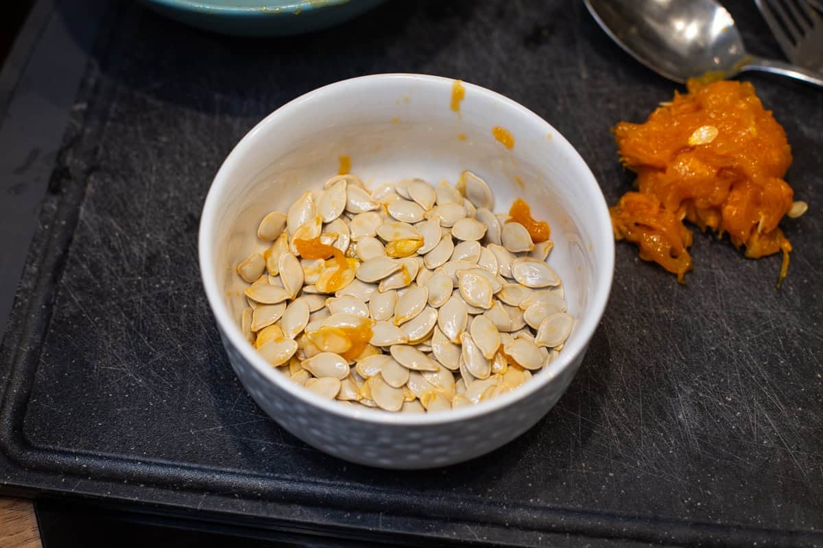 A bowl of raw pumpkin seeds.