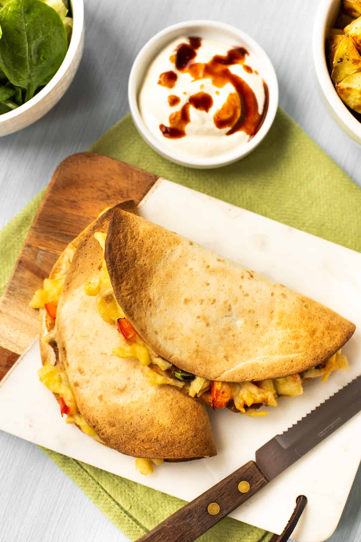 Overhead shot of two vegetarian air fried quesadillas on a board.