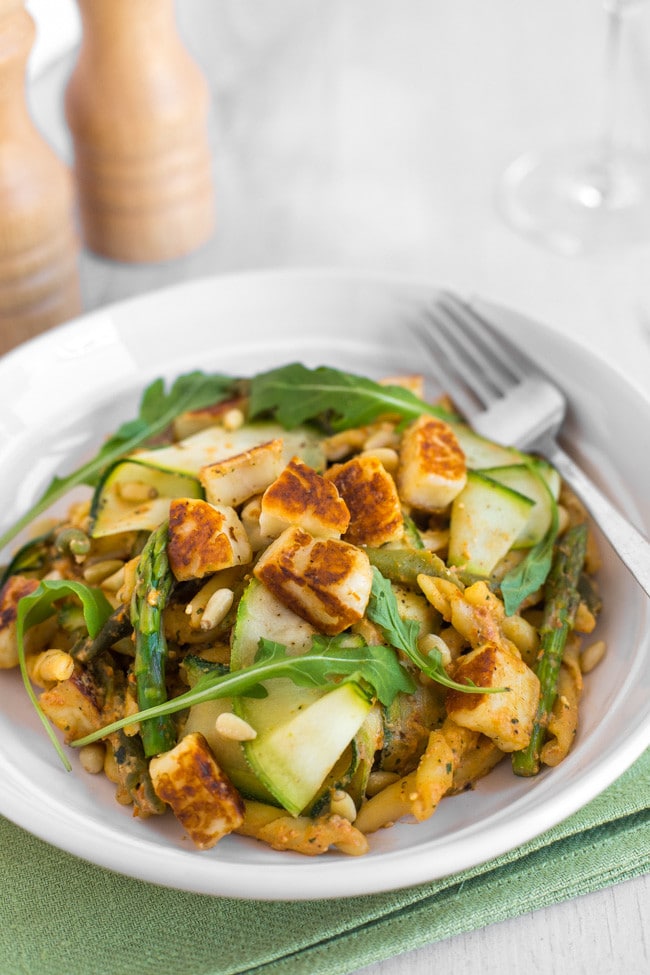 A bowlful of tomato pesto pasta with asparagus and courgette ribbons.