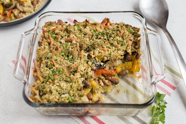 Bean and vegetable crumble in a Pyrex baking dish with a scoop removed