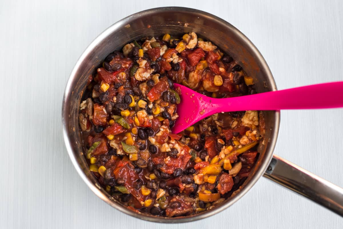 Vegetarian chilli with beans and halloumi in a saucepan.