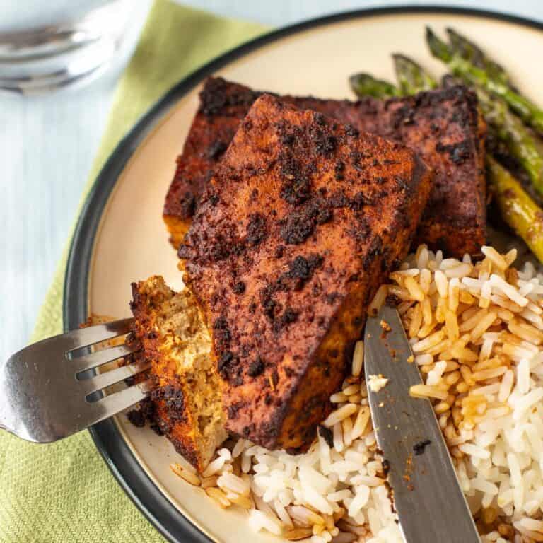 Blackened tofu steaks being cut open.