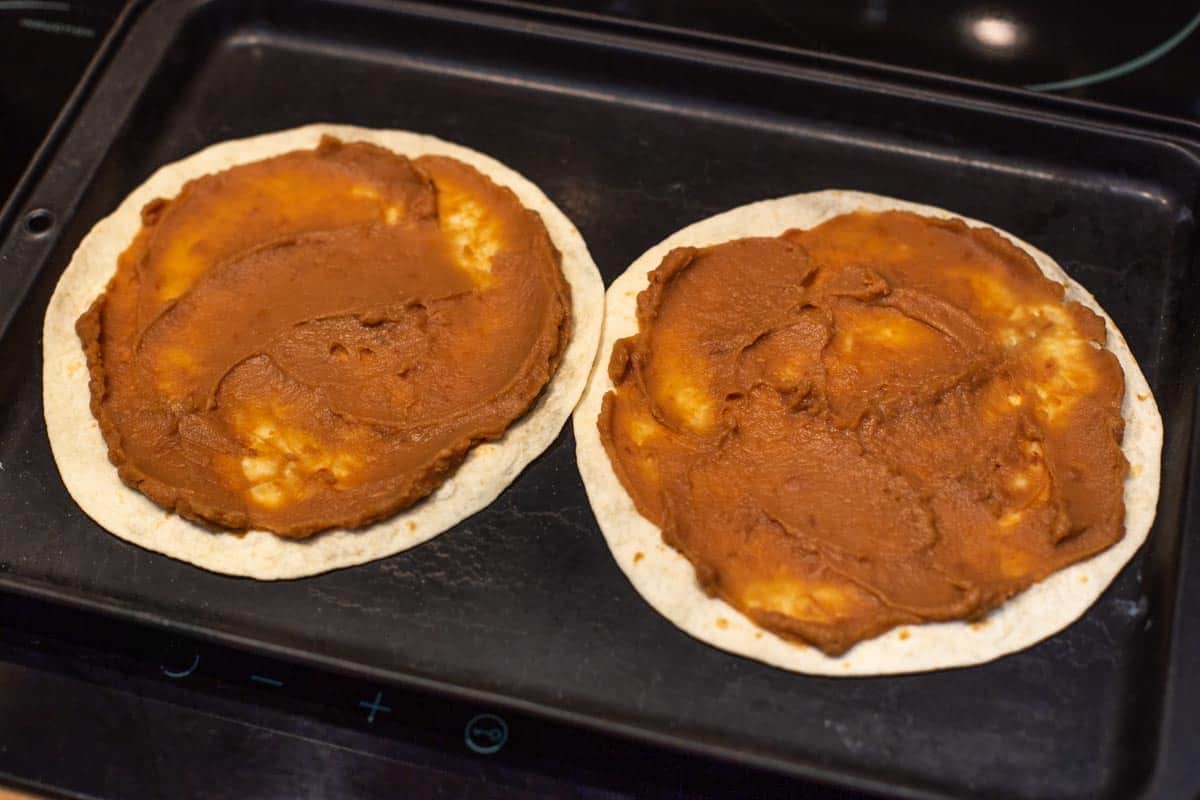 Refried beans spread on mini tortillas.