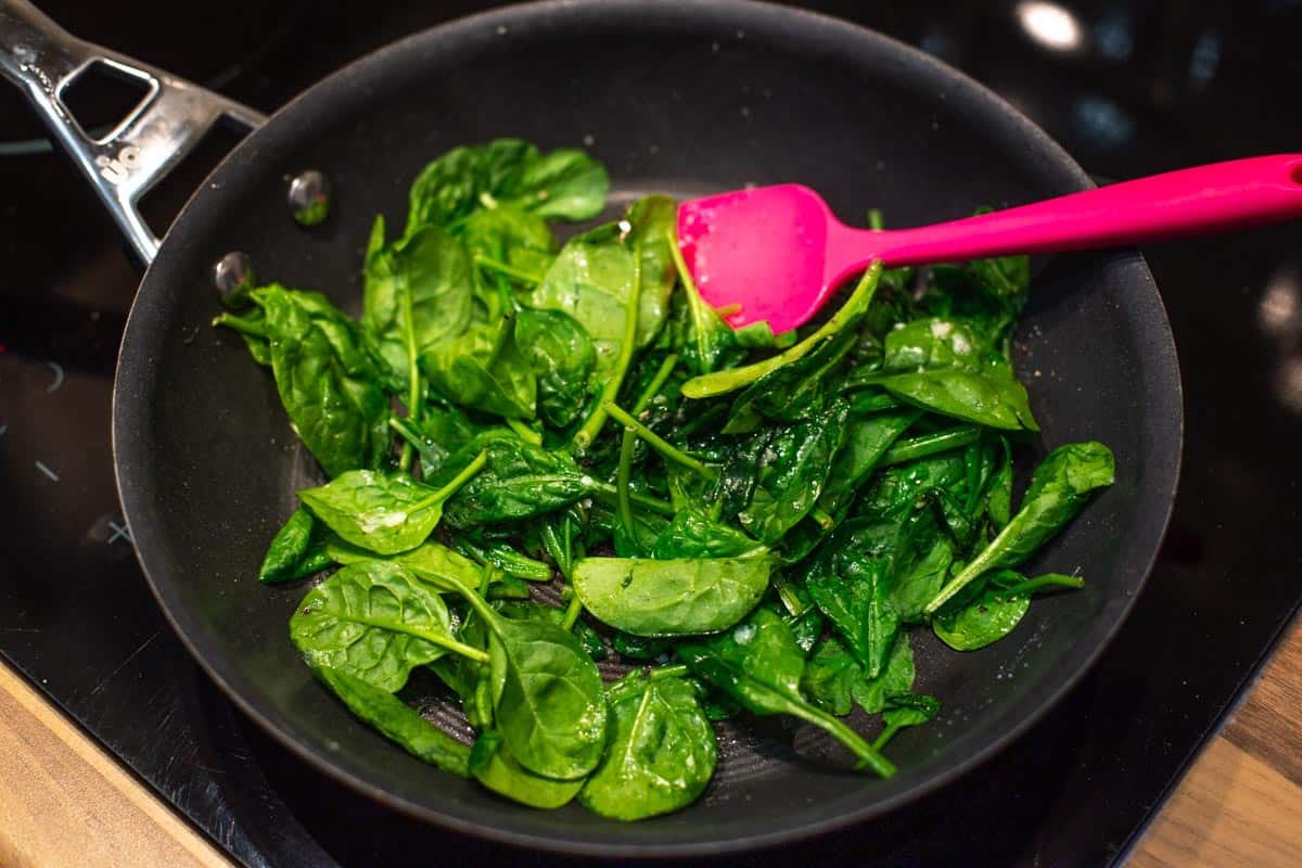 Spinach wilting in a frying pan.