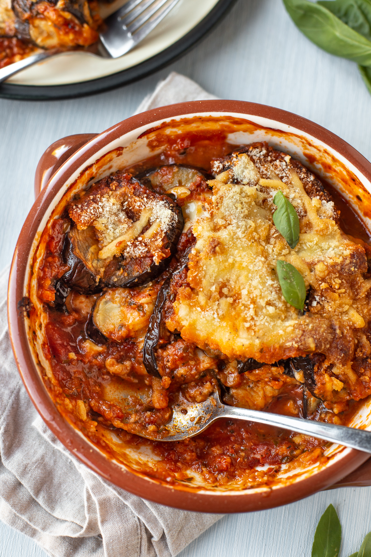 A cheesy eggplant bake in a baking dish with a portion removed.
