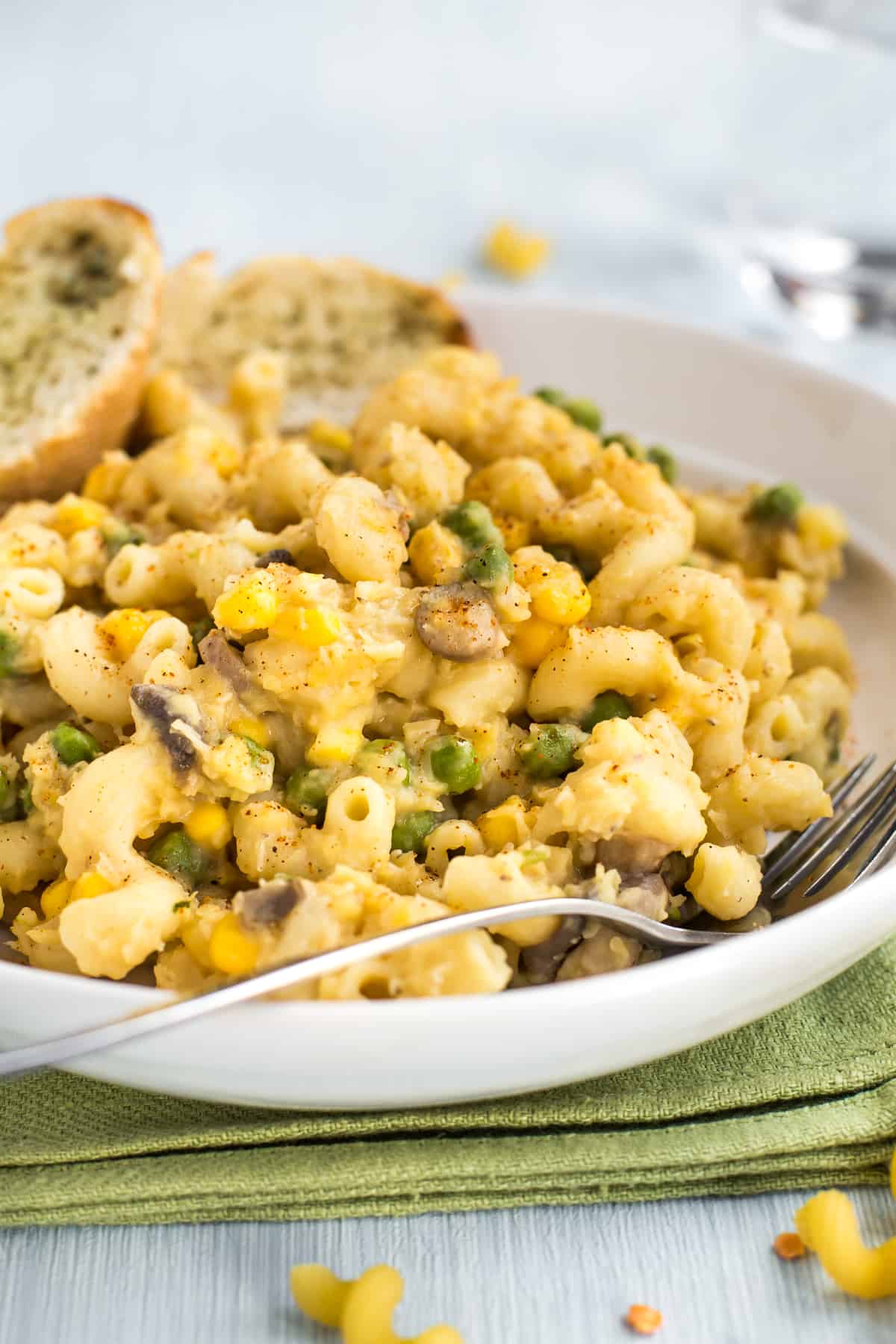 Close up photo of cheesy lentil pasta with vegetables.
