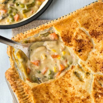 Overhead shot of a cheesy vegetable pie being scooped into.