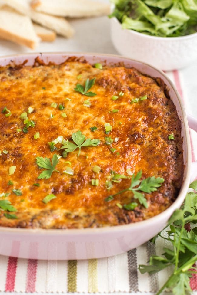 Cherry tomato clafoutis with a crispy cheesy topping in a pink baking dish