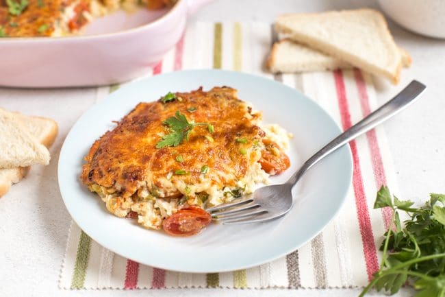 Portion of savoury cherry tomato clafoutis on a plate with a fork