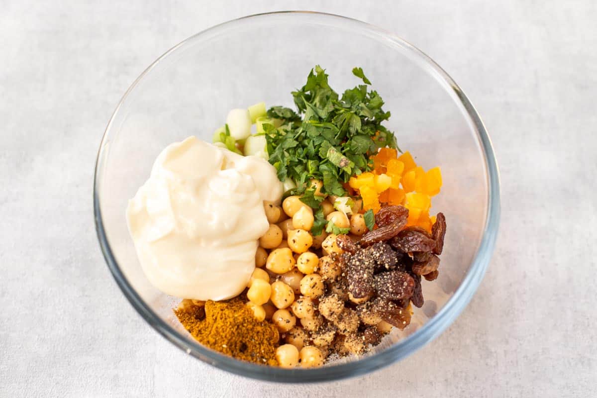 Ingredients for coronation chickpeas in a mixing bowl.