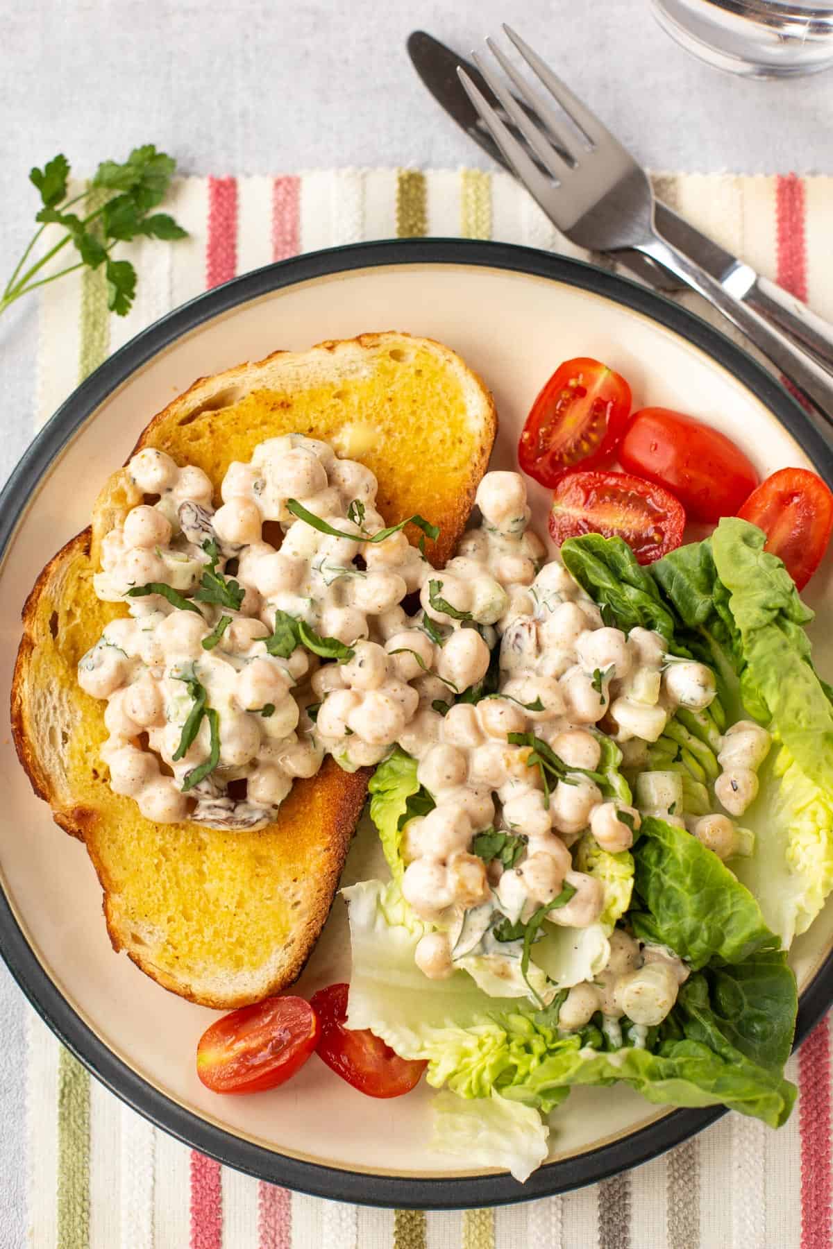 Creamy coronation chickpeas served on toast and salad.
