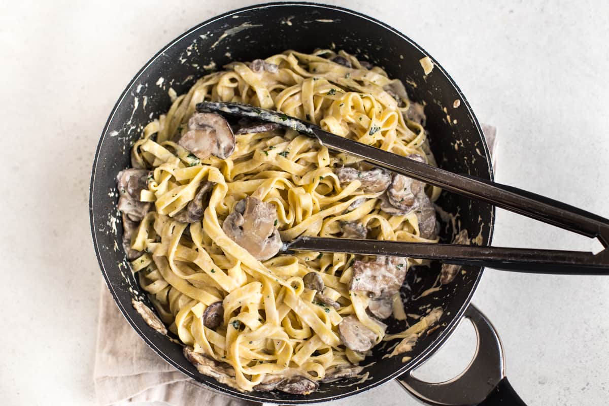 Creamy garlic mushroom tagliatelle in a frying pan.