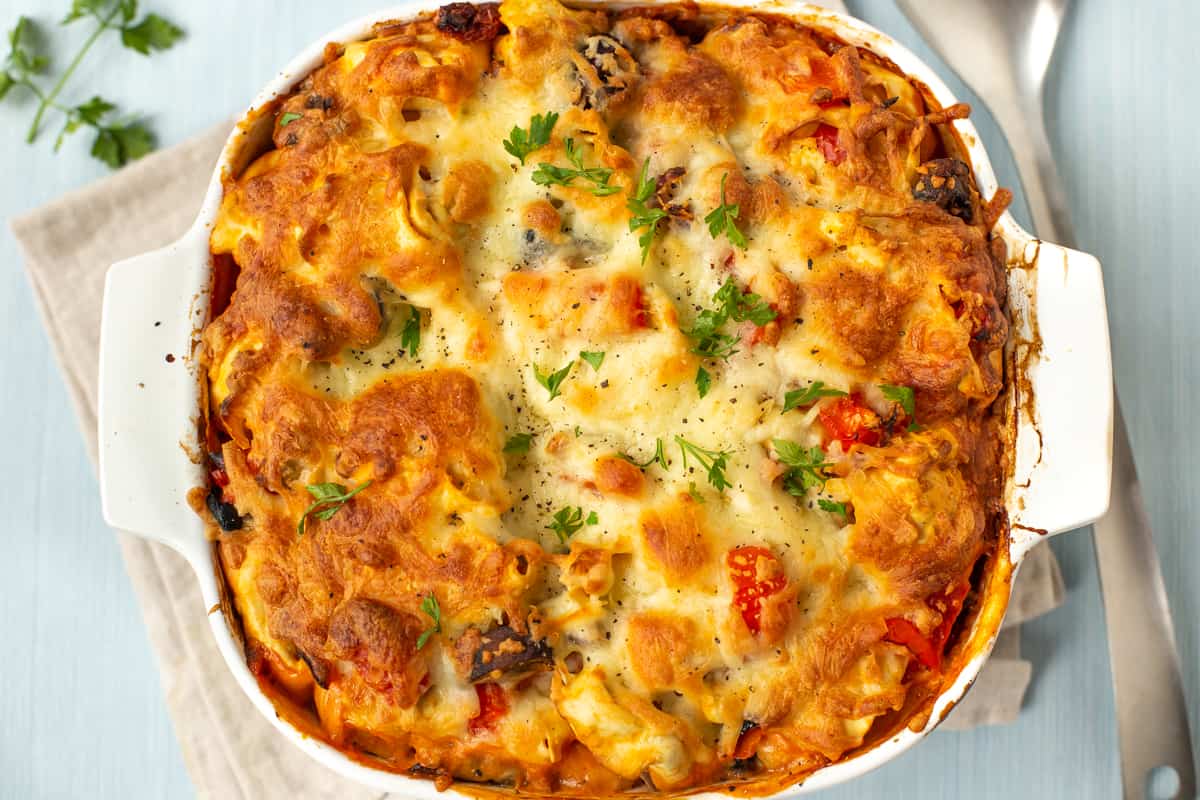 Aerial view of a cheesy pasta bake with a crispy cheese topping.
