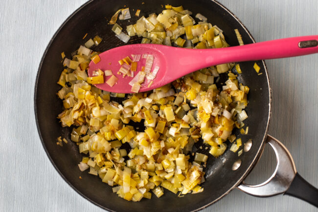 Buttered leeks cooking in a frying pan.