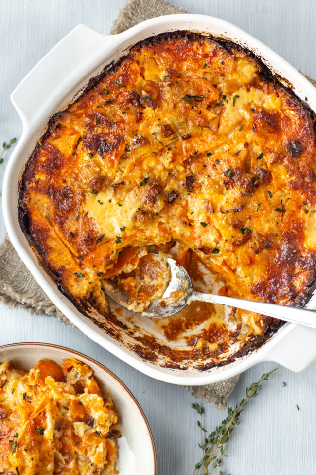 Creamy sweet potato bake in a dish with a scoop being removed.