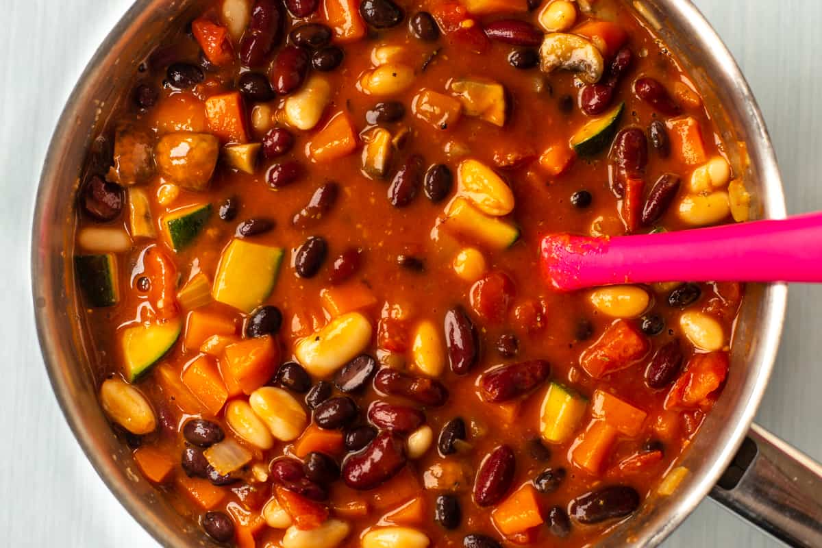 Three bean stew being cooked in a saucepan.