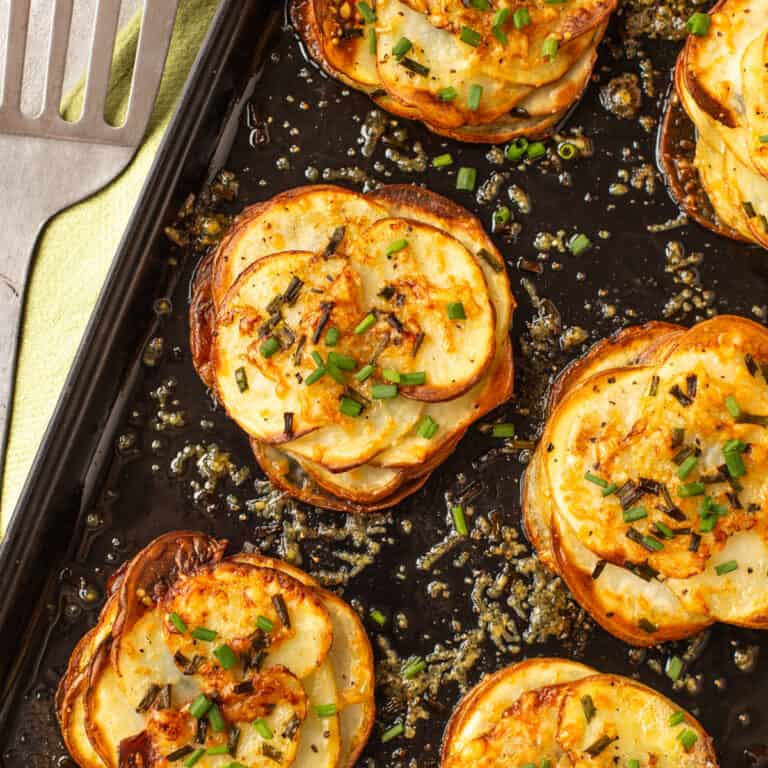 Square image of Easy Cheesy Potatoes Anna on a baking sheet.