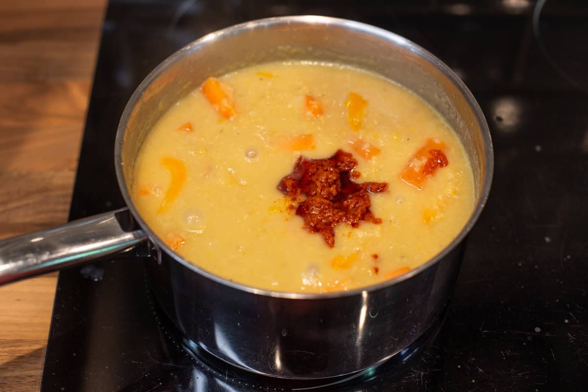 Unblended red lentil soup with a dollop of red pesto.