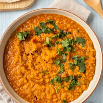 Bowl of tarka dal topped with fresh cilatro.
