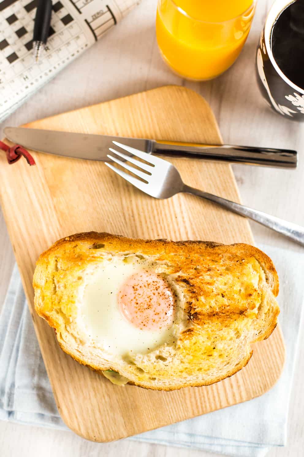 Aerial shot of a breakfast sandwich with an egg cooked into the bread.