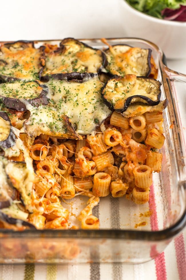 Eggplant parmesan pasta bake in a baking dish with a portion removed