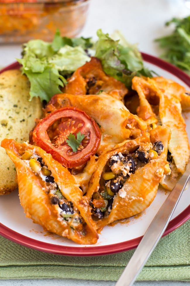 Portion of enchilada stuffed pasta shells on a plate.
