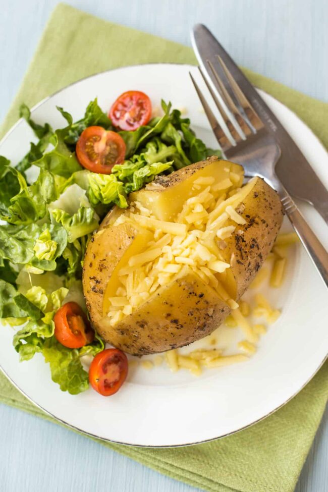 A cheesy jacket potato with salad.