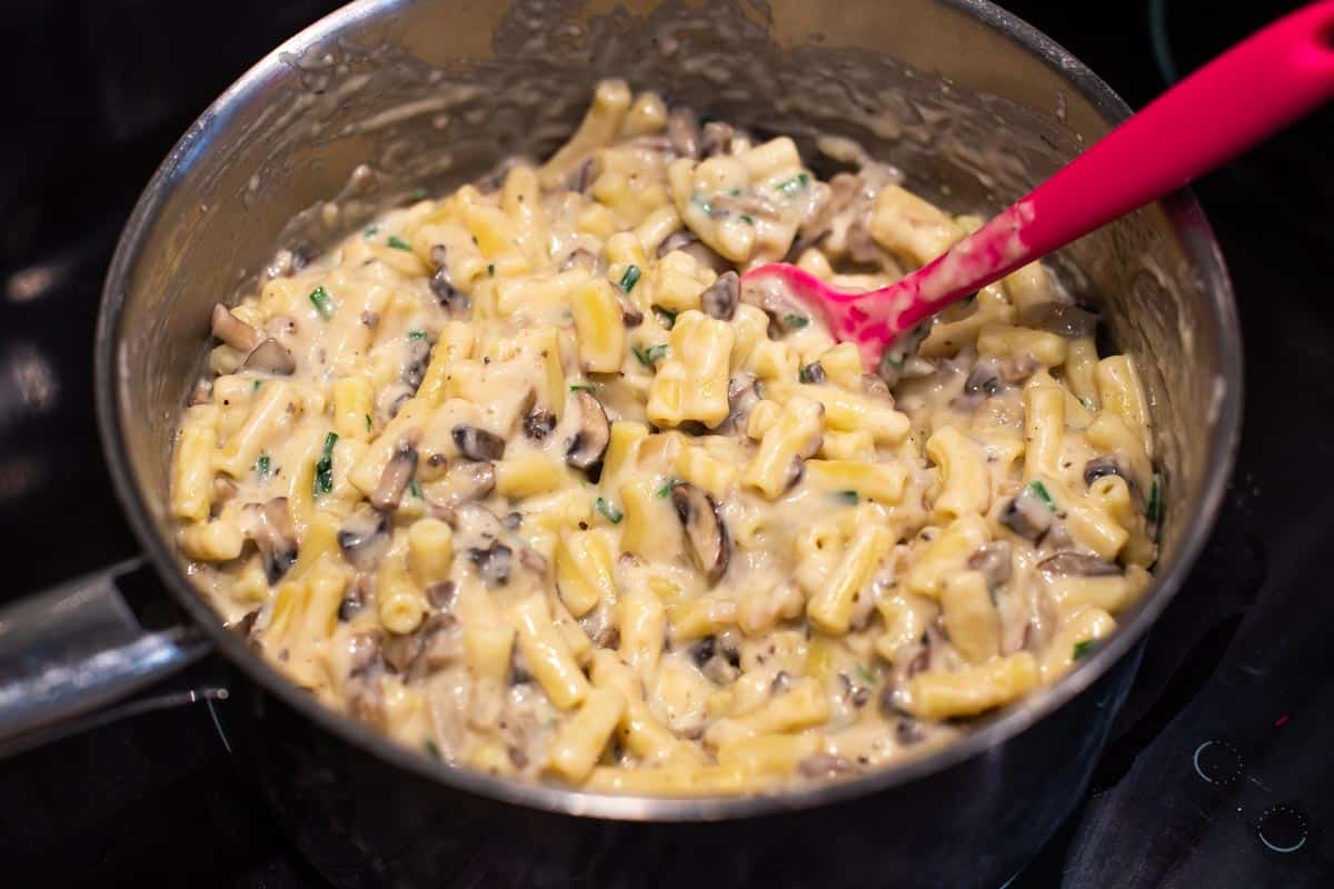 Creamy garlic mushroom mac and cheese in a saucepan.