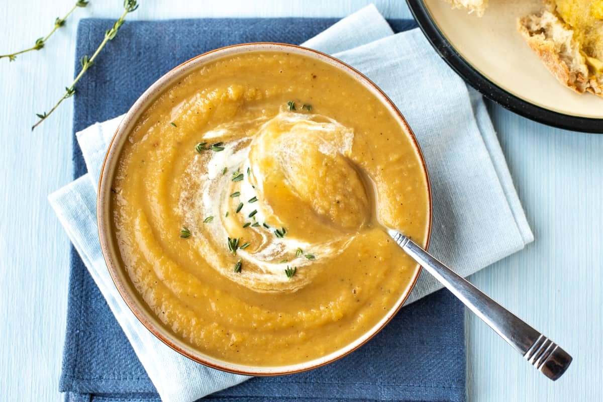 A bowlful of roasted parsnip soup with a spoon dipped in.