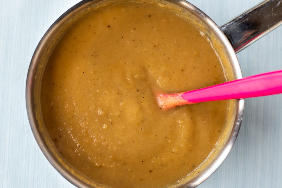 Blended roasted parsnip soup in a saucepan.