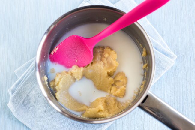 Milk being added to a simple roux in a saucepan