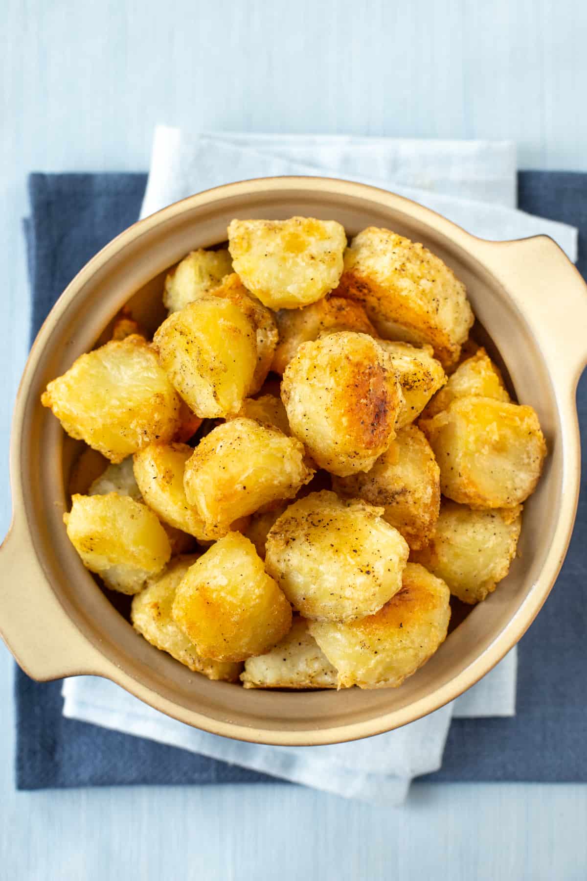 Aerial shot of a serving bowl piled high with roast potatoes.