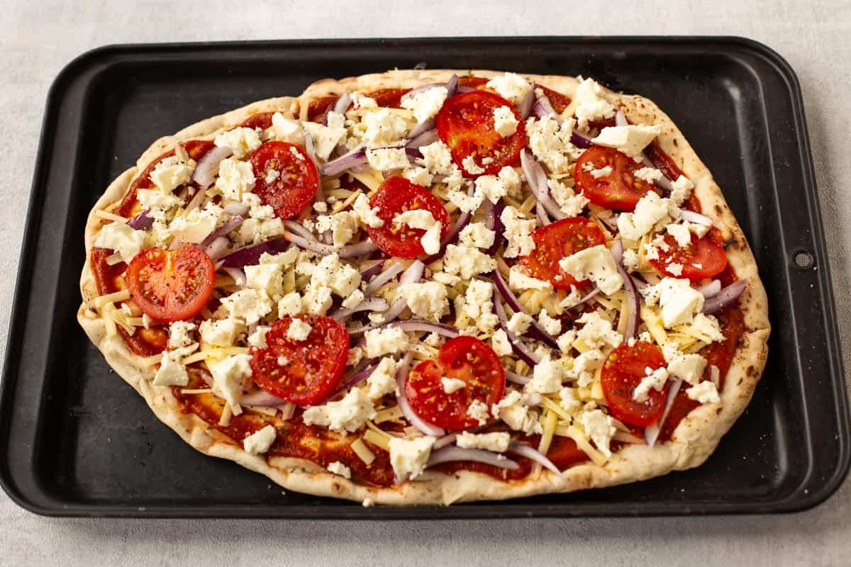 Uncooked Indian pizza on naan bread.