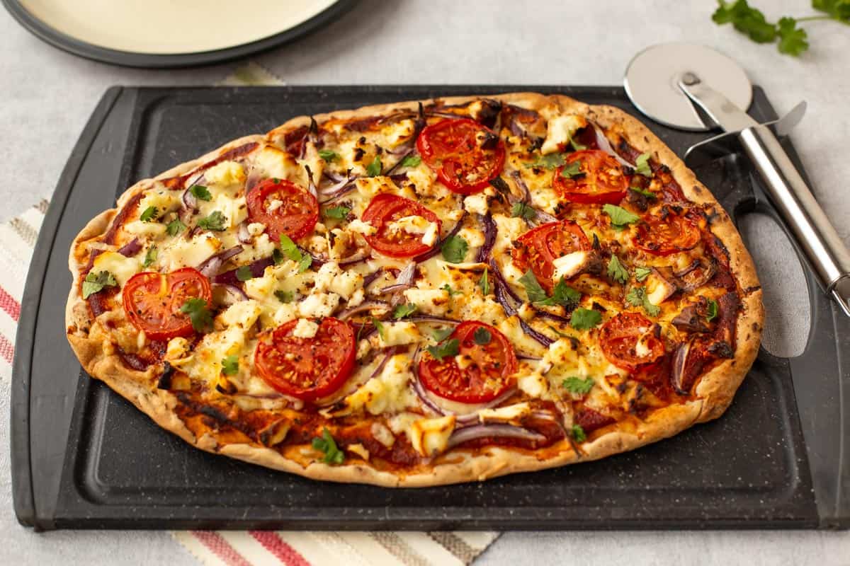Indian pizza on naan bread with paneer cheese.