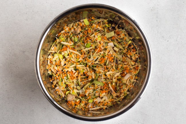 Uncooked lentils, rice and vegetables in the Instant Pot bowl