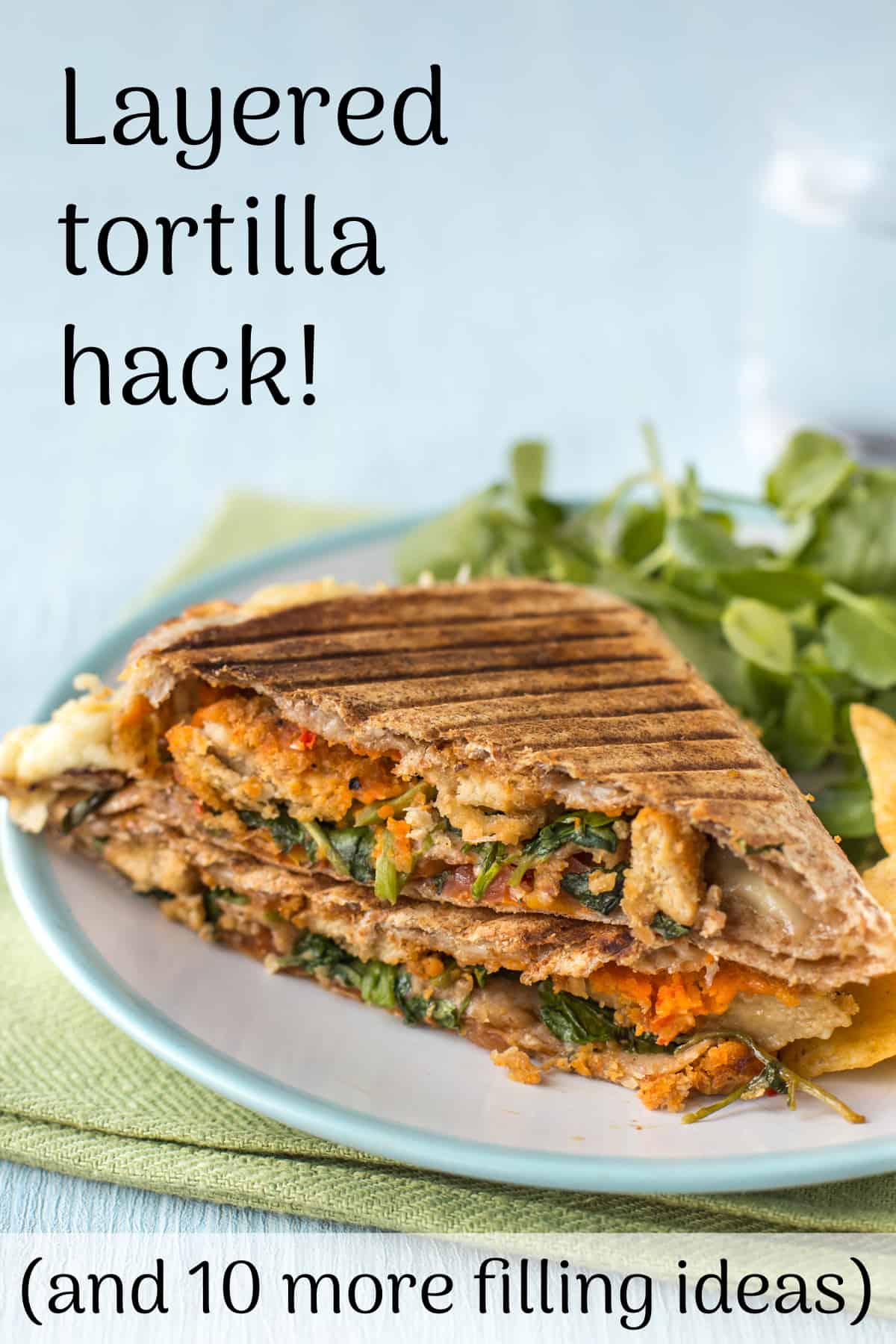A grilled tortilla stuffed with vegetarian nuggets and watercress on a plate.