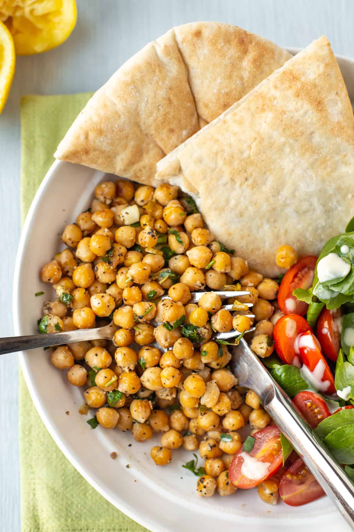 A fork scooping up some lemony pepper chickpeas.