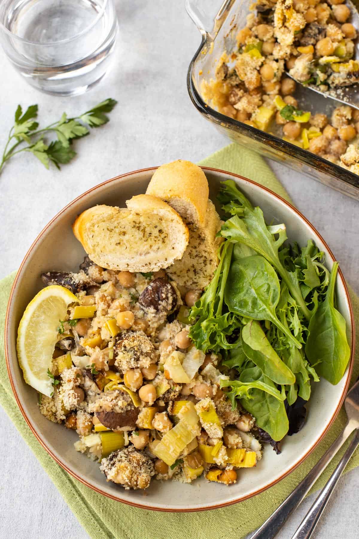 Lemony chickpea casserole served with garlic bread and lettuce.