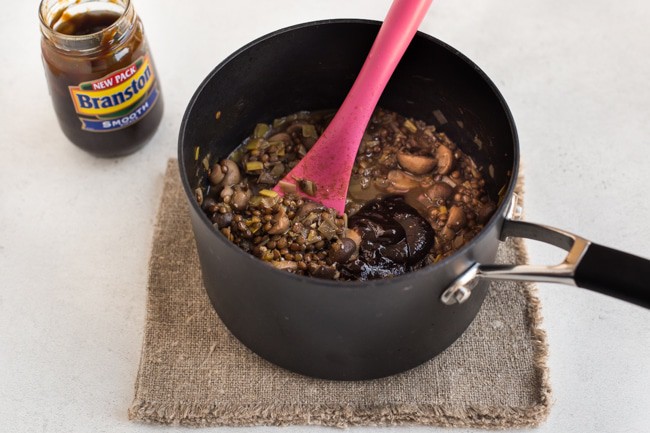 Lentil and mushroom stew with Branston pickle in a saucepan