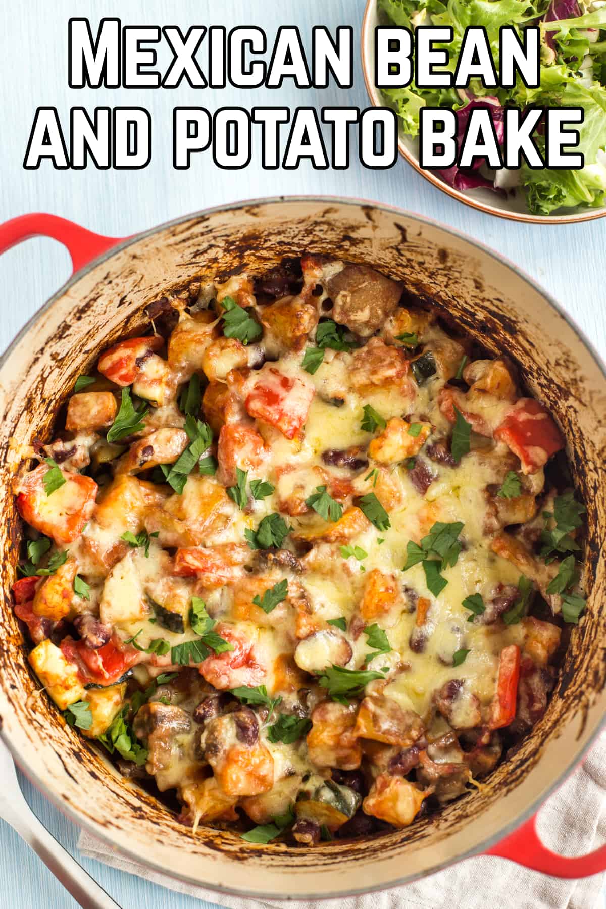 Mexican bean and potato bake in a casserole dish topped with cheese.