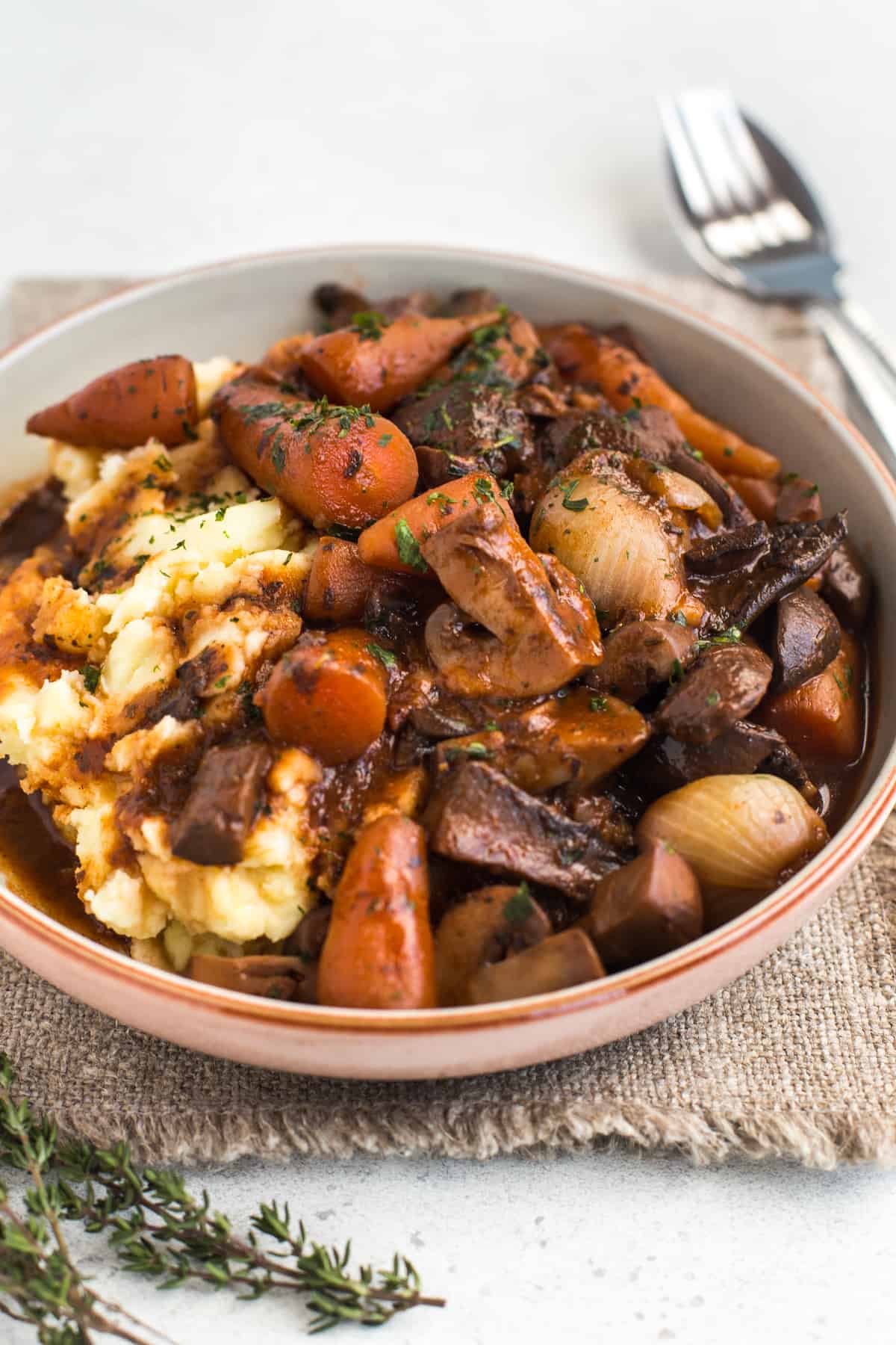 Portion of vegan bourguignon with mashed potatoes in a bowl.