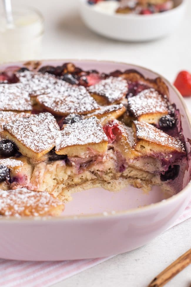 Baked pancake pudding in a baking dish with a portion removed