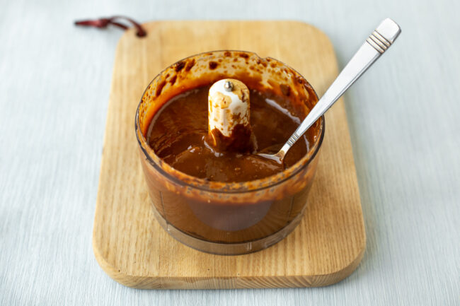 A silky peanut sauce in a food processor bowl.