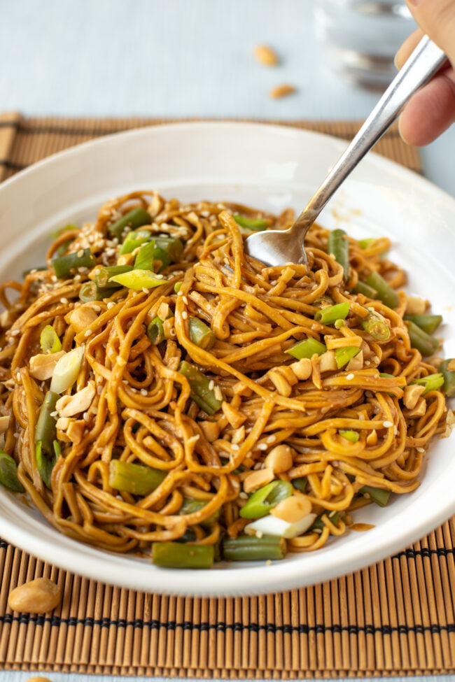 Peanut and sesame noodles being twirled by a fork.