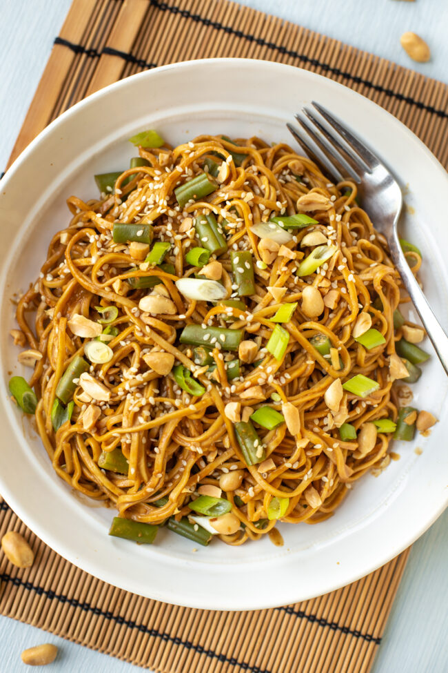 Aerial shot of peanut noodles with lots of toppings.