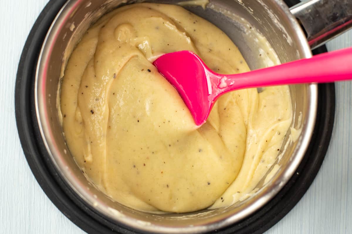 Cheesy Welsh rarebit sauce in a saucepan.