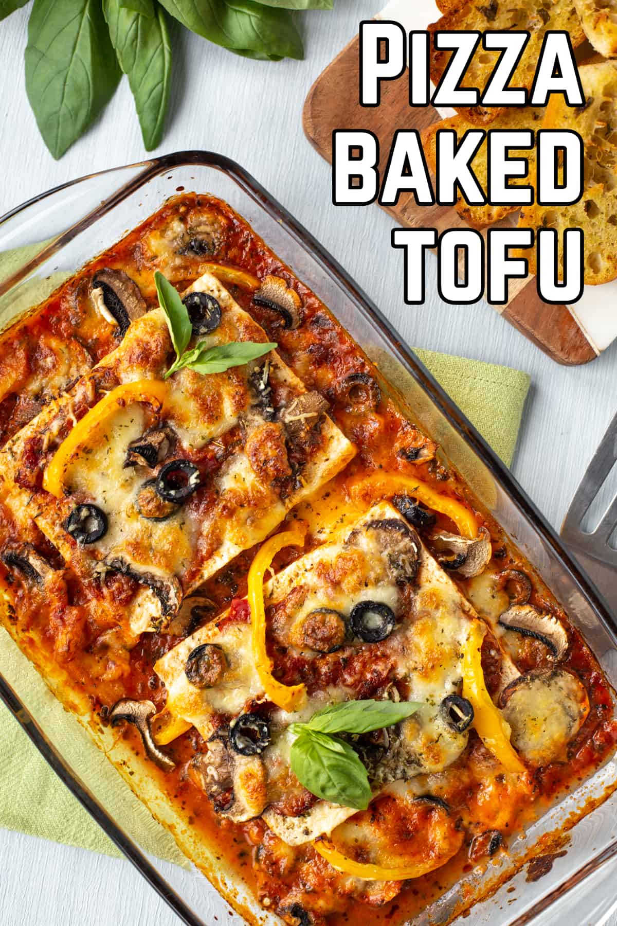 Aerial shot of tofu baked in a dish, topped with cheese and pizza toppings.